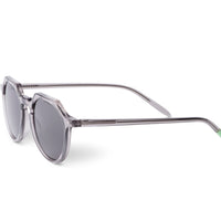 Round sunglasses with transparent gray frame and dark lenses, temple extended