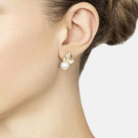 Gold butterfly drop earrings with rhinestone wings and white pearl on earlobe