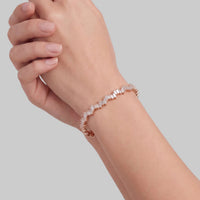 Rose gold ice cuff bangle with baguette-cut clear stones on wrist