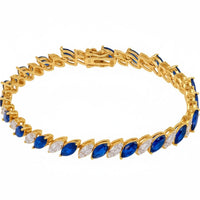 Gold tennis bracelet with oval blue gemstones in linked settings