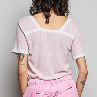 Baby pink textured short-sleeve T-shirt with white lace trim at back neckline