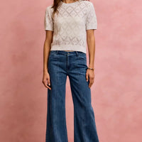 Mid-rise stretch denim jeans with wide flared legs and centered front seam