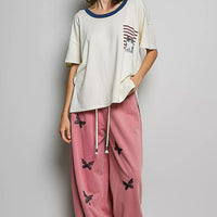 Cream cotton top with blue neckline trim and American flag graphic