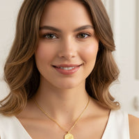 Gold-tone chain necklace with round pendant worn by model