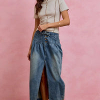 Washed denim midi skirt with front slit and button waistband, worn