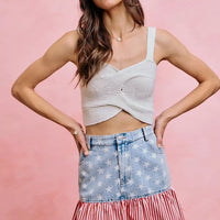 Blue denim mini skirt with star print top section and red-and-white striped ruffled hem.