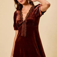 Burgundy velvet mini dress with lace V-neck, bow tie, and short puff sleeves.