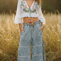 Ivory cropped blouse with floral embroidery, V-neck tie and ruffled hem