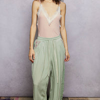 Rose pink V-neck ribbed cami with lace trim and thin spaghetti straps, full look.