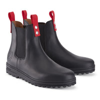 Pair of black leather Chelsea boots with red pull tabs and thick lug soles.