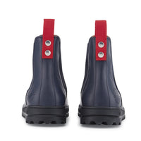 Rear view of navy Chelsea boots with red pull tabs and lugged soles