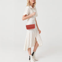 Red leather shoulder bag on a model, front flap and gold chain strap