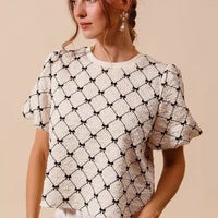 Ivory woven bubble sleeve top with black bow texture pattern, short puff sleeves