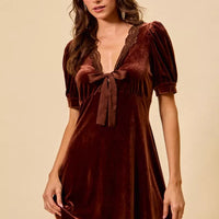 Burgundy velvet mini dress with lace V-neck, short sleeves, and tied bow front.
