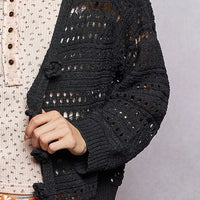 Black open-knit button cardigan close-up of crochet pattern and front buttons