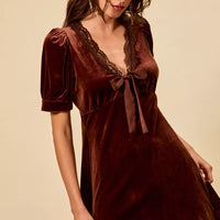 Burgundy velvet mini dress with lace-trim V-neck and bow tie, short puff sleeves.
