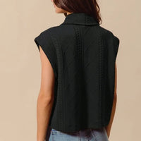 Black knit quilted vest with cable pattern, no visible front buttons