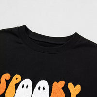 Close-up of black crewneck sweatshirt neckline with partial embroidered graphic