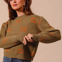 Olive crewneck sweater with orange pumpkin rhombus pattern, ribbed cuffs and hem