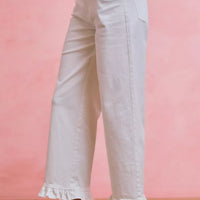 White mid-rise wide-leg jeans with ruffled cuffs and side pockets