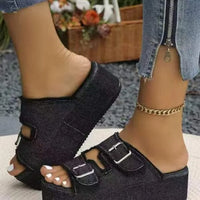 Black textured wedge sandals with two wide straps and square metal buckle details