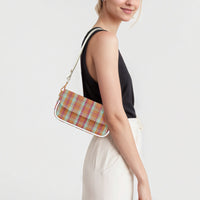 Plaid shoulder bag worn sideways with white strap and gold chain