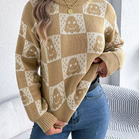 Tan checkerboard Halloween sweater with jack-o-lantern face graphics and ribbed cuffs