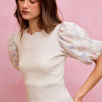 White rib knit sweater top with floral contrast puff sleeves and scalloped hem