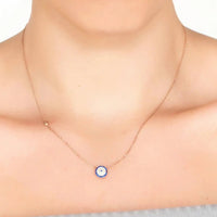 Rose gold evil eye necklace with small blue eye pendant on neckline