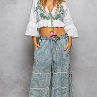Ivory floral embroidered cropped blouse with V-neck tie, tassels and ruffled hem