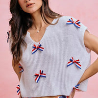 Off-white dolman sweater top with ribbon bows and a simple crew neckline