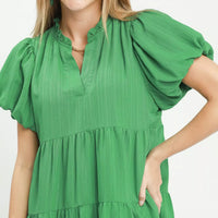 Green babydoll dress close-up with V-neck and puff sleeves