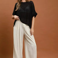 Cream high-waist wide-leg trousers with pleated front and ankle-length wide legs