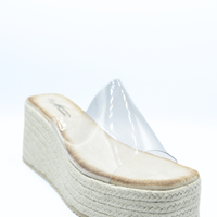 Beige platform wedge slide sandals with clear upper and espadrille-textured midsole