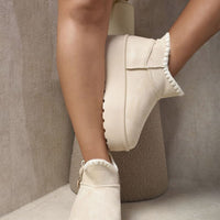 Cream suede ankle boots with faux fur lining, side buckle strap, and chunky platform sole.