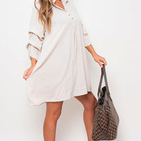 White shirt dress with collar, button front, and loose three-quarter sleeves.