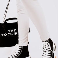 Black and white high-top platform trainers with orange tread soles
