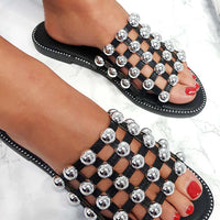 Black flat slide sandals with silver studded lattice straps and open toe