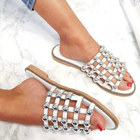 Studded lattice flat slide sandals on feet, rhinestone grid straps with tan sole