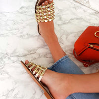 Nude flat slide sandals with studded lattice straps, open toe and low flat sole