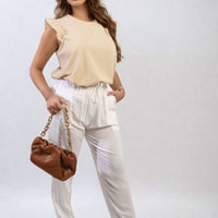 Cream high-waist drawstring trousers with side pockets and relaxed tapered legs