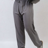 Grey high-waist drawstring trousers with side pockets and relaxed wide-leg shape.