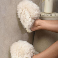 Cream faux fur open-back slippers, worn with visible soft slip-on design