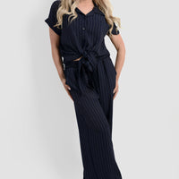 Navy pinstripe tie-front shirt and wide-leg trousers, full body side view