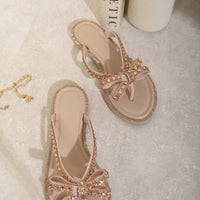 Nude flat thong sandals with rhinestone bow, decorative edge trim, toe post
