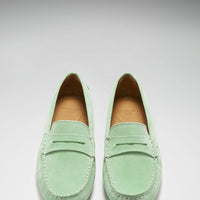 Pair of green suede loafers shown from above, with penny straps and stitched apron toes.