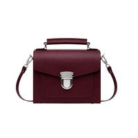 Marsala red leather satchel handbag with top handle, flap, and front clasp