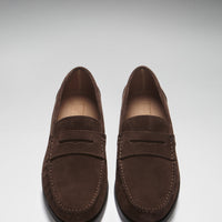 Pair of brown suede loafers shown from above, with stitched toes and penny straps