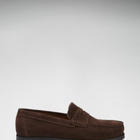 Brown suede loafer in side profile with a penny strap and black sole