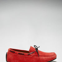 Red suede loafer with black lacing and a side view of its low-profile sole